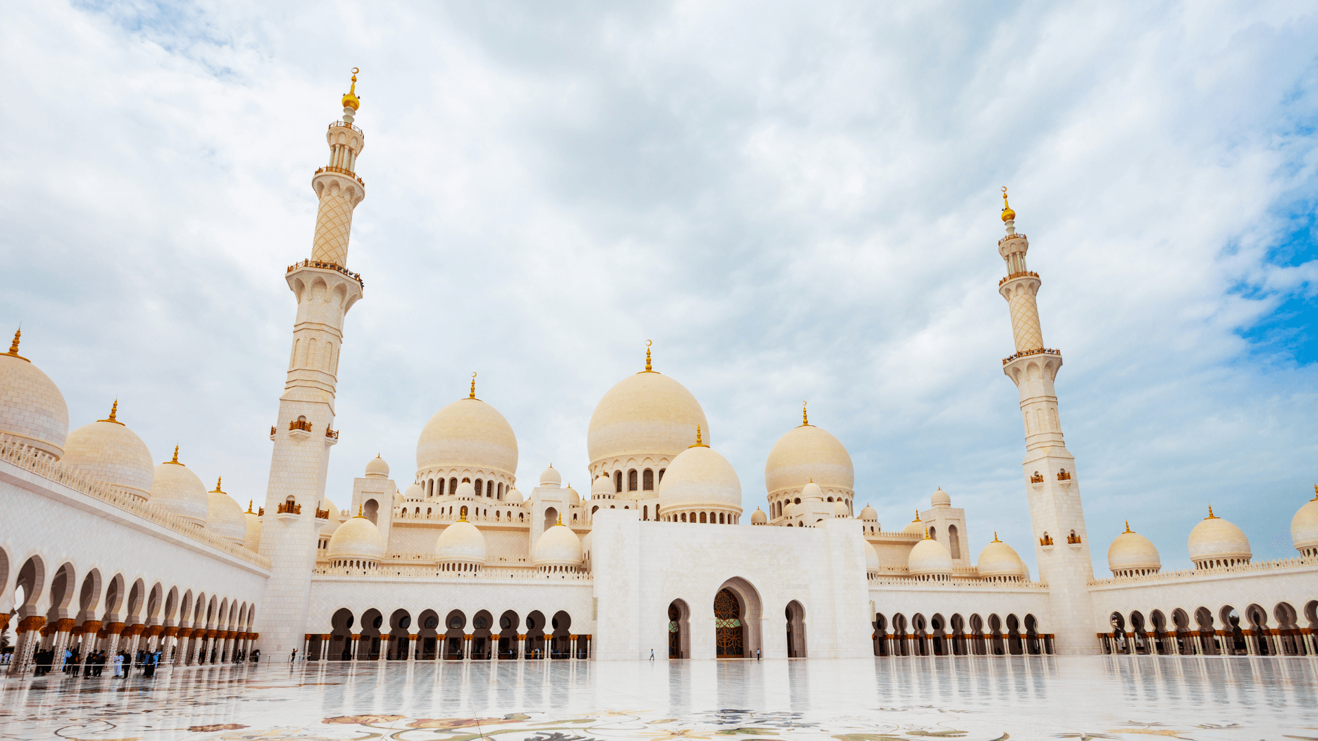"Marvel at the majestic white domes and intricate designs of the Sheikh Zayed Grand Mosque."