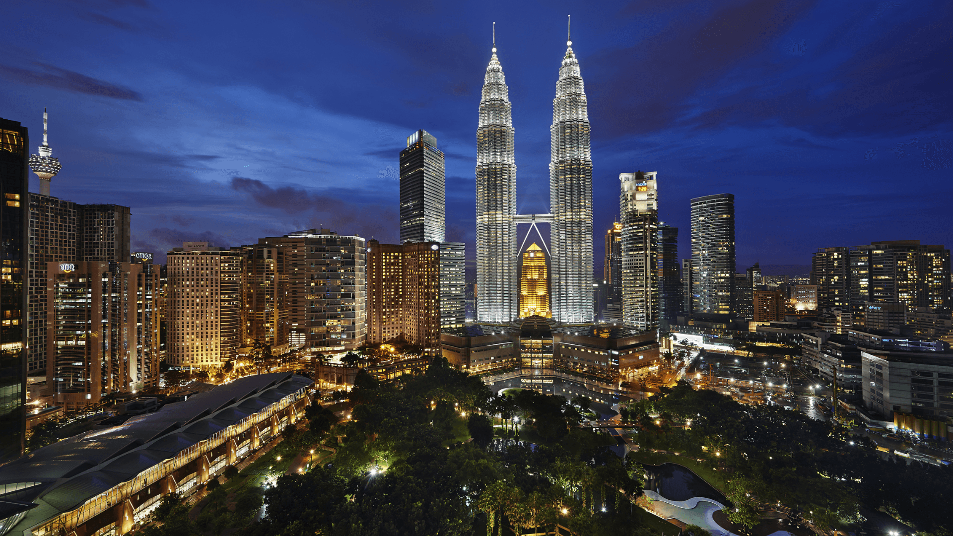 Soaring 452 meters above Kuala Lumpur, the Petronas Twin Towers offer breathtaking views from the Skybridge and Observation Deck, dazzling night lights, world-class shopping at Suria KLCC, serene moments at KLCC Park, and a touch of culture at the Petronas Art Gallery and Philharmonic Hall.